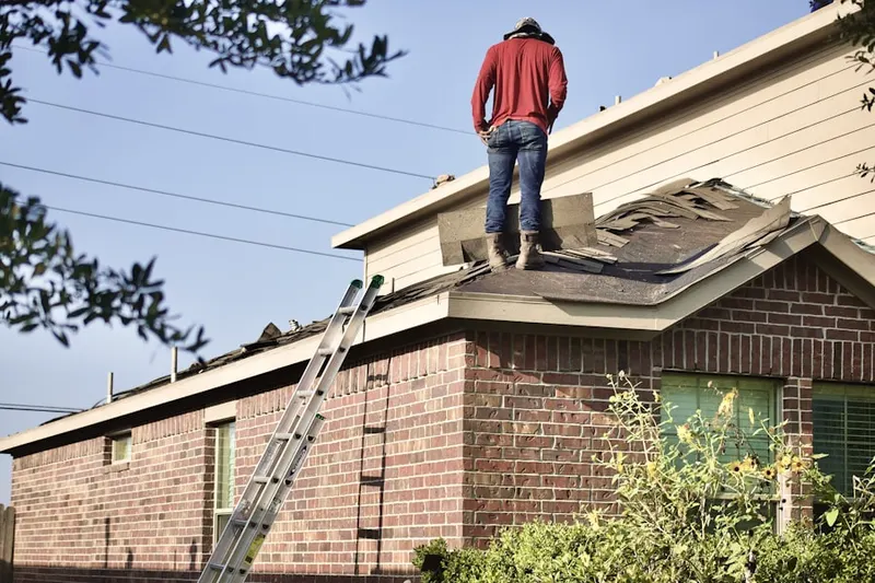 Professional roofer working on a residential roof in Woods Pond
